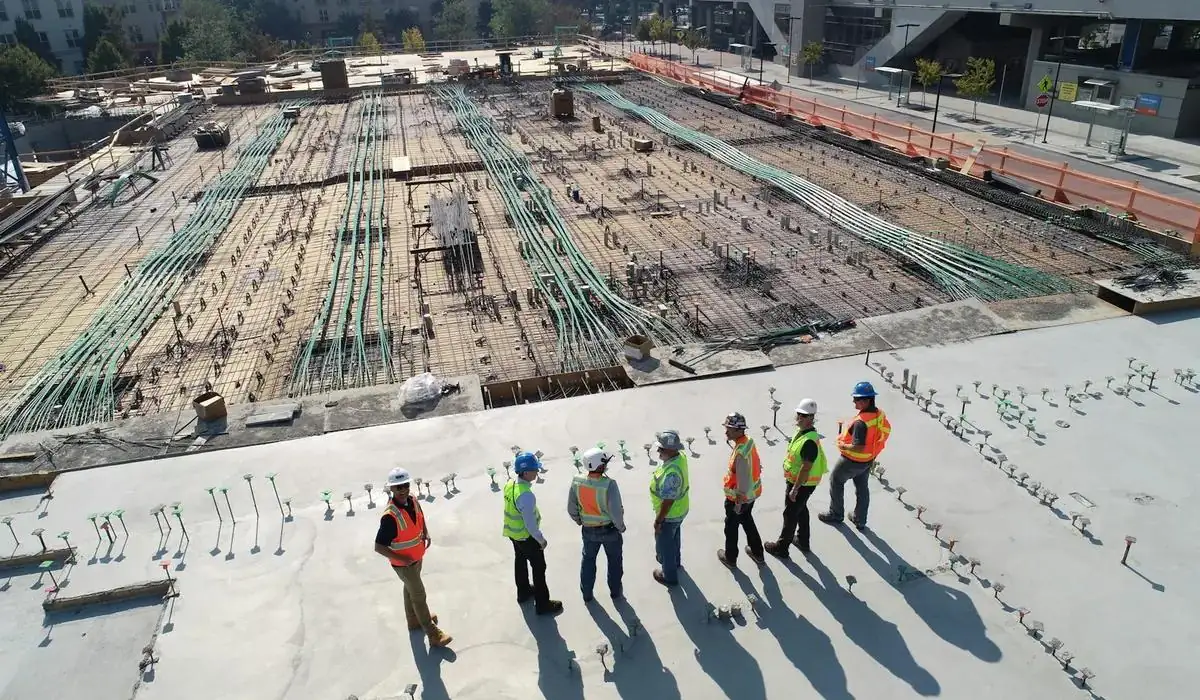 A large roofing crew working across a building under construction